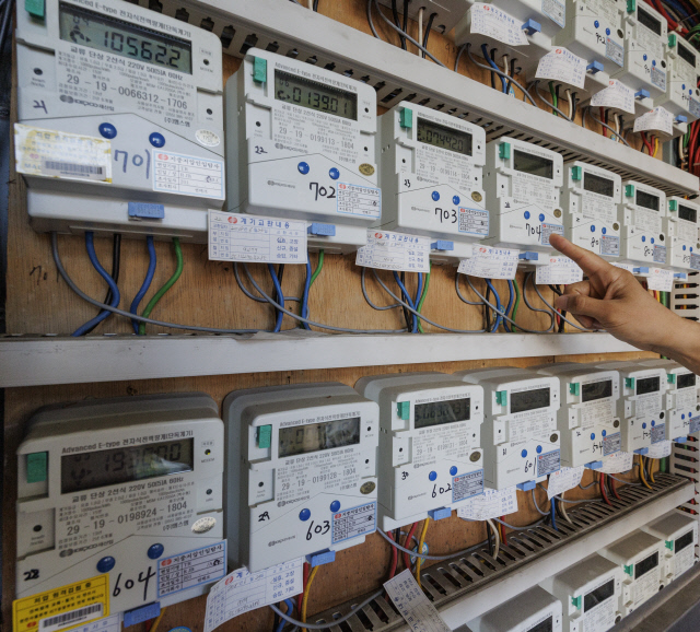 지난 23일 오전 서울 중구의 한 집합 건물 관계자가 이 건물에 설치된 전력량계를 점검하고 있다. <연합뉴스>